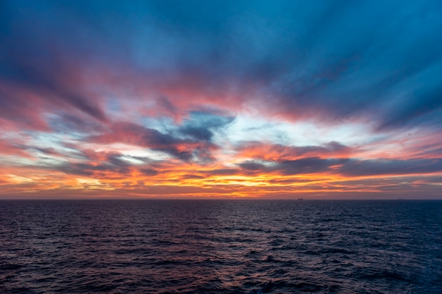 Sunset at sea. Seascape, blue sea.  Calm weather. View from cargo vessel.