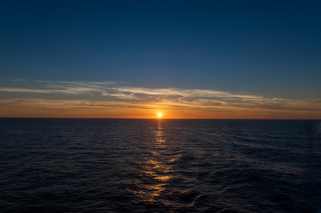 Sunset at sea. Seascape, blue sea.  Calm weather. View from cargo vessel.