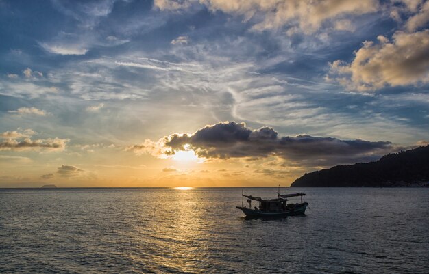 Sunset over the sea with two small boats. 