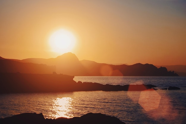 Sunset seascape mountains silhouettes at golden hour