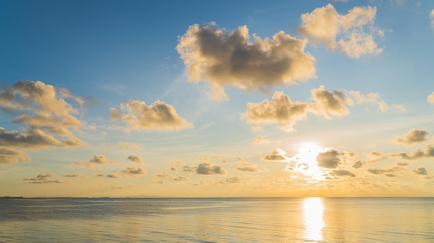 Sunset sky clouds over sea in the evening with colorful orange sunlight reflect on the sea