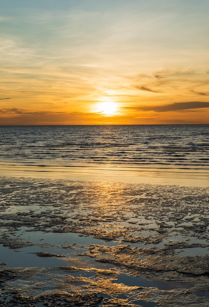 Sunset sky clouds vertical over sea in the evening with colorful orange sunlight reflect on the sea