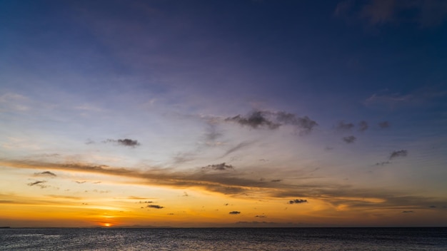 Sunset sky over sea in the evening on dusk twilight with orange sunlight