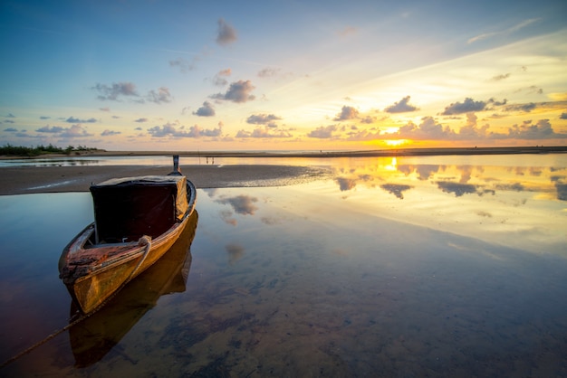 Sunset sky and sea landscape with wooden boats. 