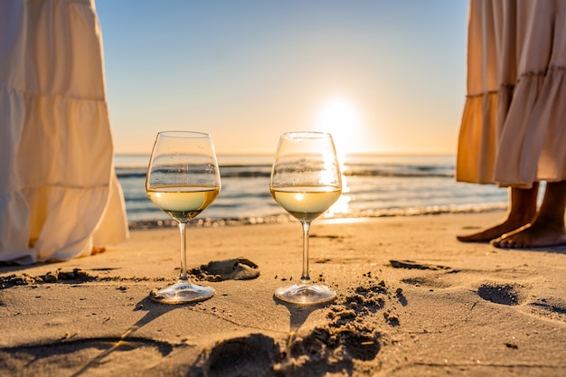 sunset or sunrise beach party scene with two unrecognizable multiracial boho girls 