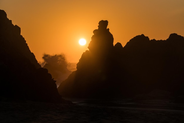 Sunset view of rocks on a hidden Praia Da Ursa Ursa Beach near Cabo Da Roca on Atlantic coast Portugal