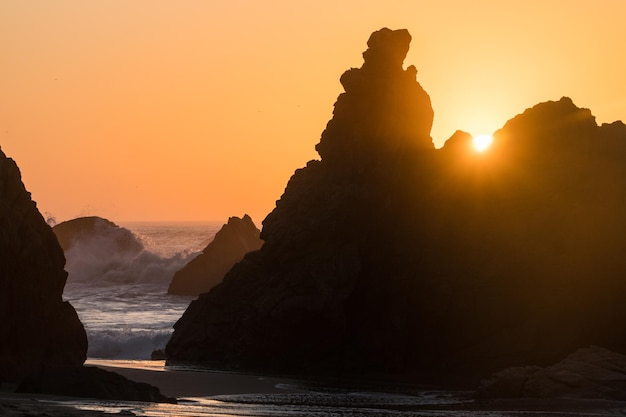 Sunset view of rocks on a hidden Praia Da Ursa Ursa Beach near Cabo Da Roca on Atlantic coast Portugal