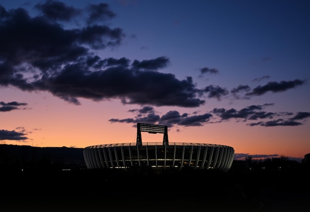 Photo a sunset view of a stadium with the scoreboard on the top