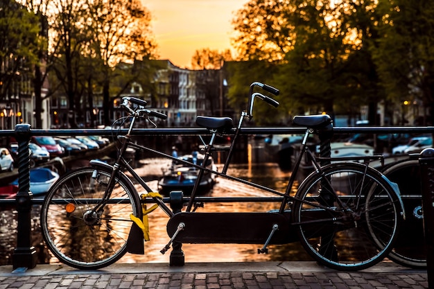 Sunset view with bridge, bicycles and water reflection in Amsterdam city, Netherlands