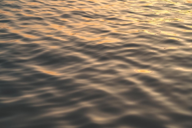 Sunset water reflect ripples at sun light Abstract golden reflection on water sunset