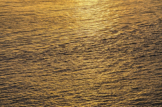 Sunset water reflect ripples at sun light Abstract golden reflection on water sunset