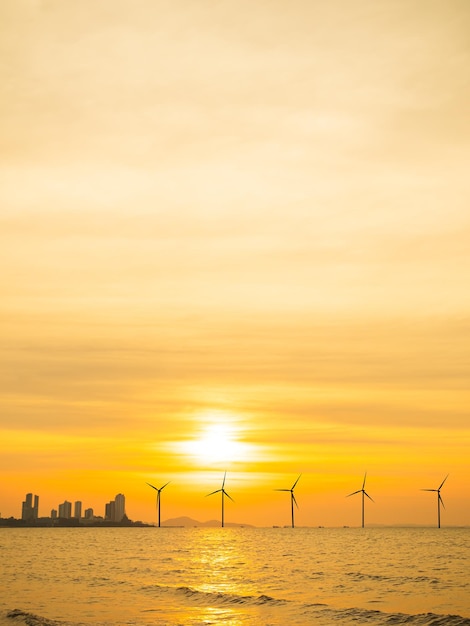 A sunset over a wind farm with a city in the background