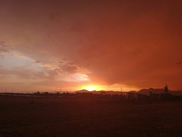 a sunset with a red sky and a few clouds