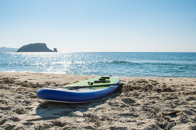 Sup board for riding on the water lies on the seashore