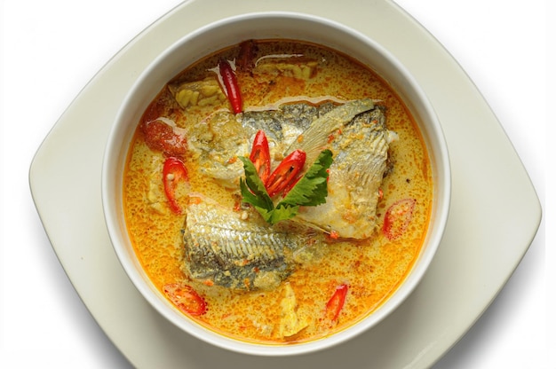 Sup Kari Ikan or Fish curry soup is served in a white bowl with spicy curry spices