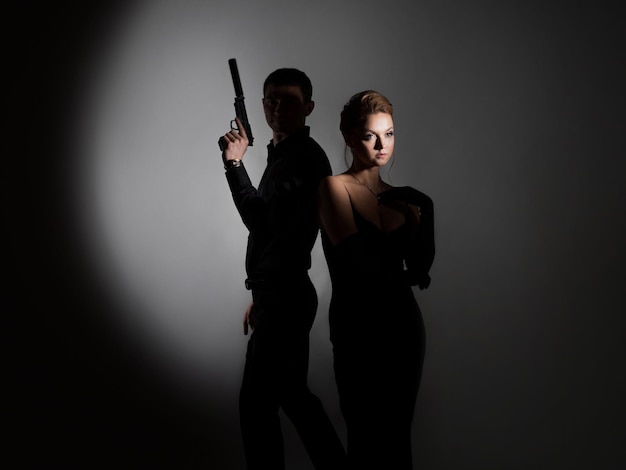 Super agents a gorgeous blonde in a black evening outfit and a man with a gun behind her back a luxu...