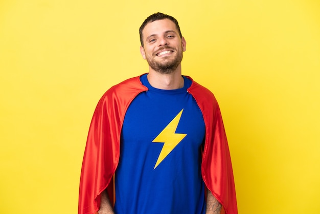 Photo super hero brazilian man isolated on yellow background laughing