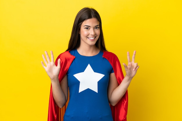 Super Hero Brazilian woman isolated on yellow background counting eight with fingers