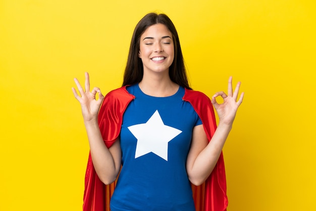 Super Hero Brazilian woman isolated on yellow background in zen pose