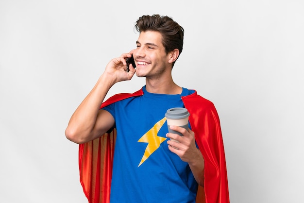 Super Hero caucasian man over isolated white background holding coffee to take away and a mobile