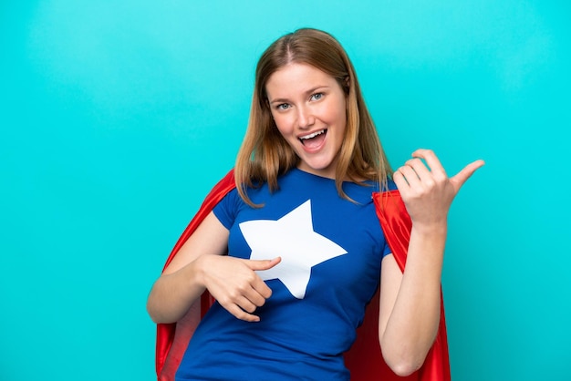 Super Hero caucasian woman isolated on blue background making guitar gesture