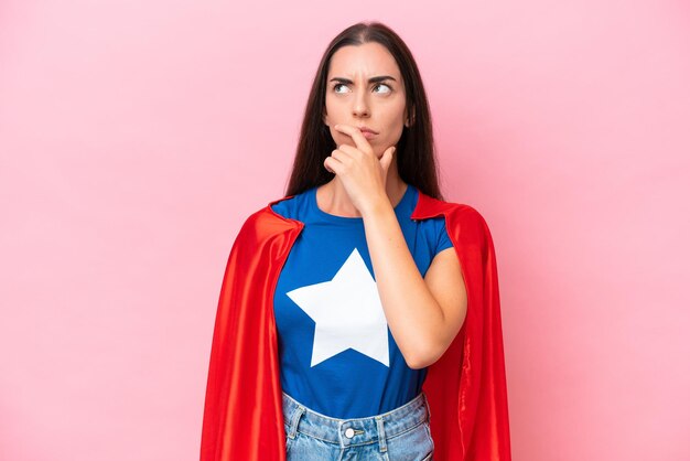 Super Hero Caucasian woman isolated on pink background