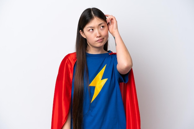 Super Hero Chinese woman isolated on white background having doubts and with confuse face expression