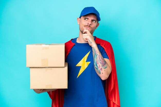 Photo super hero delivery man over isolated background having doubts and thinking