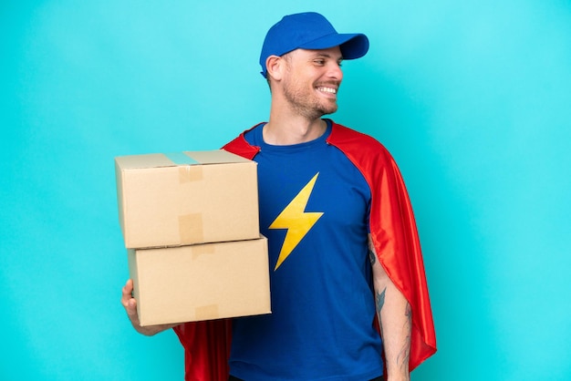 Photo super hero delivery man over isolated background looking side