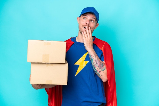 Photo super hero delivery man over isolated background looking up while smiling