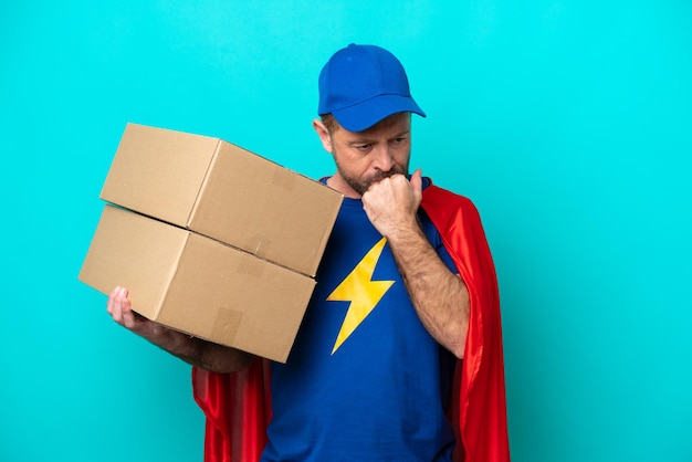 Super Hero delivery man isolated on blue background having doubts