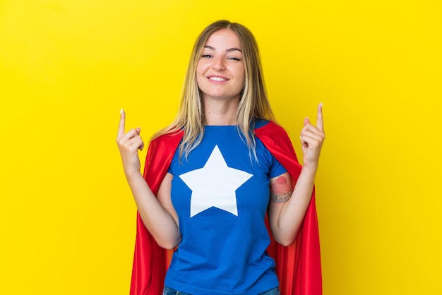 Super Hero Romanian woman isolated on yellow background pointing up a great idea