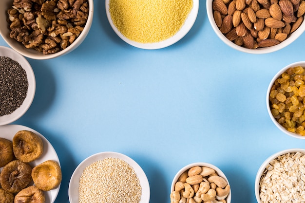 Superfoods in Bowls on blue Background.