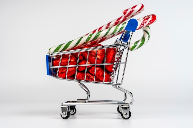 A supermarket trolley loaded with candies and Christmas caramel canes