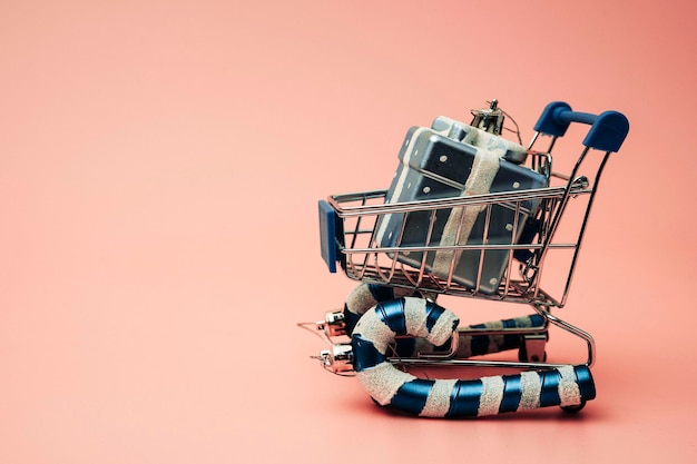 A supermarket trolley stylized as a sled carries boxes with gifts for Christmas