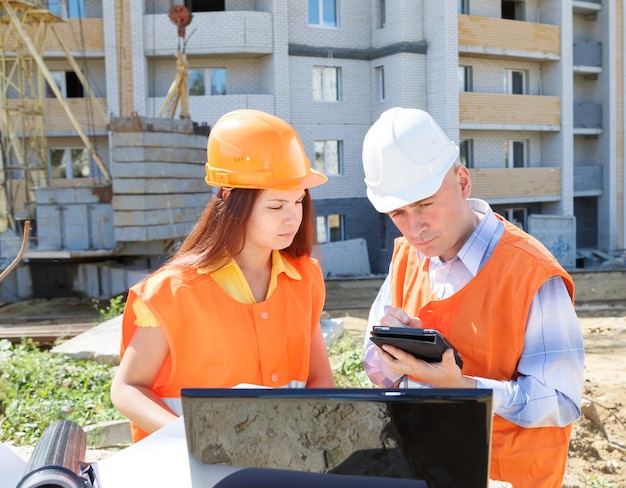 Supervisor and Subordinate employee looking at laptop Builders