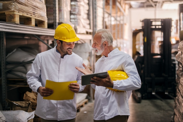 Supervisors using tablet in warehouse.