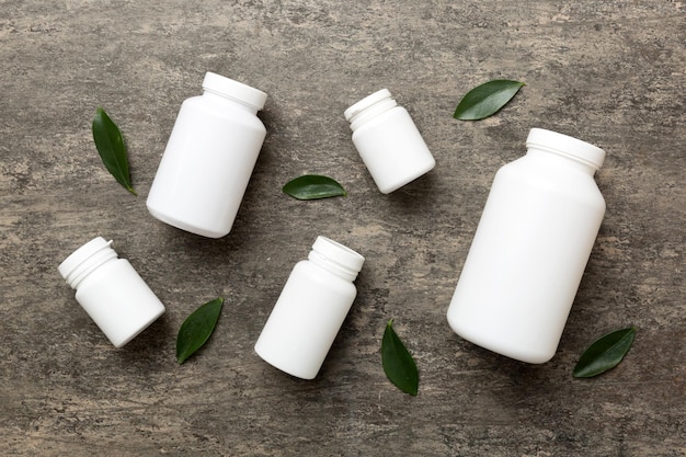 Supplement pills with medicine bottle health care and medical top view Vitamin tablets Top view mockup bottle for pills and vitamins with green leaves natural organic bio supplement copy space