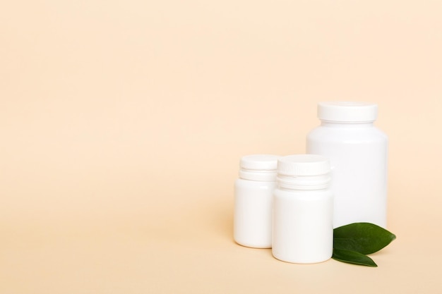 Supplement pills with medicine bottle health care and medical top view Vitamin tablets Top view mockup bottle for pills and vitamins with green leaves natural organic bio supplement copy space