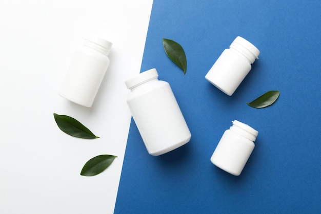 Supplement pills with medicine bottle health care and medical top view Vitamin tablets Top view mockup bottle for pills and vitamins with green leaves natural organic bio supplement copy space