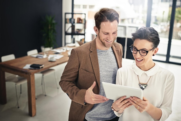 Support is crucial for the success of the project Shot of two businesspeople discussing something on a digital tablet