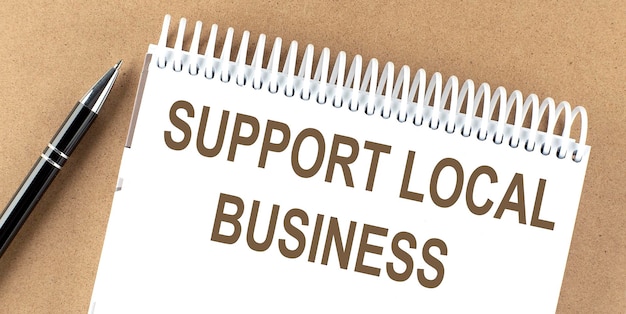 SUPPORT LOCAL BUSINESS text on a notepad with pen business