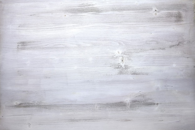 The surface of an old wood casually painted with white paint.