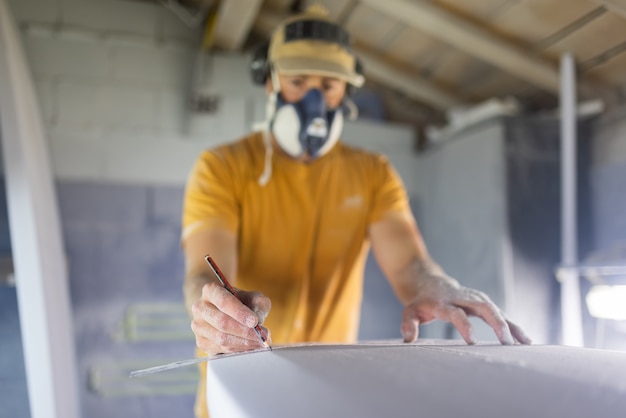 Surfboard modeling workshop  man perfecting the modeling of a surfboard shaper concept