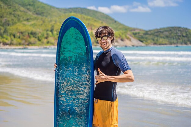 Surfer holding a surf board on beach