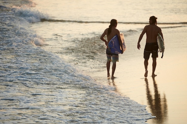 Surfers Walking on Beach