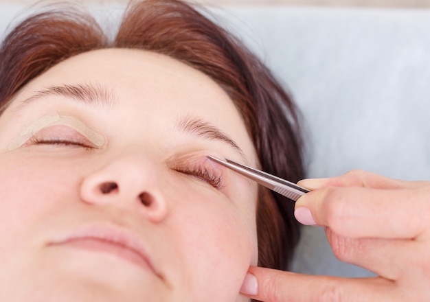 Surgeon applies a bandage to the female patient's eyelids after 