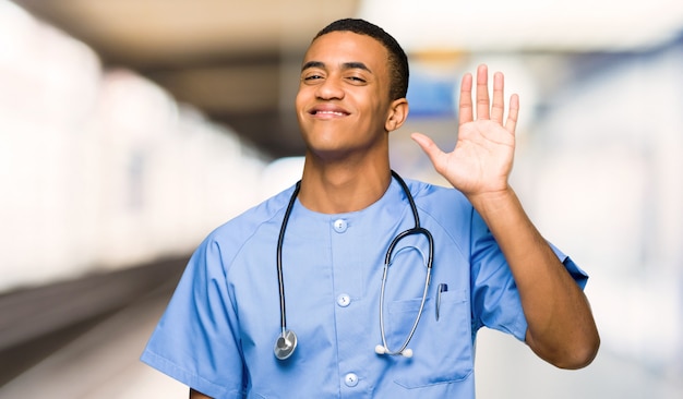 Surgeon doctor man saluting with hand with happy expression in a hospital