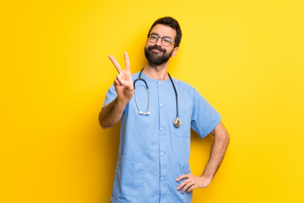 Surgeon doctor man smiling and showing victory sign