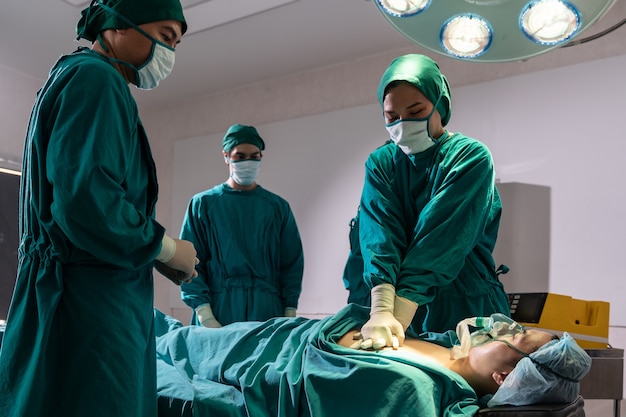 Surgeon doctor and nurse do CPR to patient